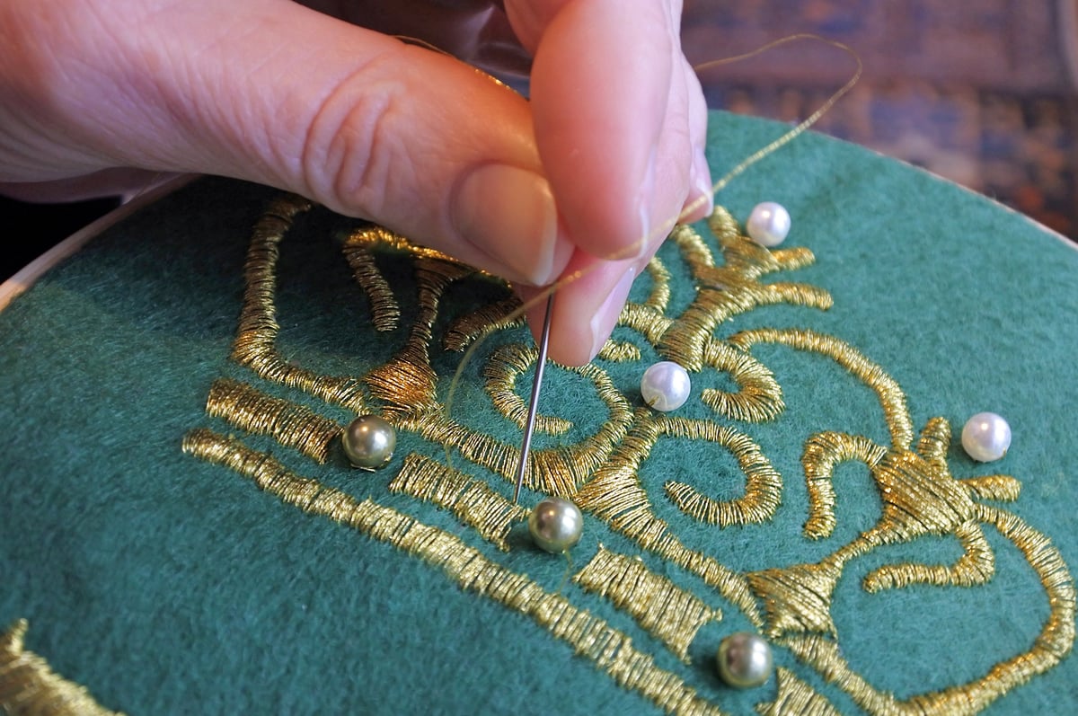 Artisan hand embroidery craft with golden threads on fabric