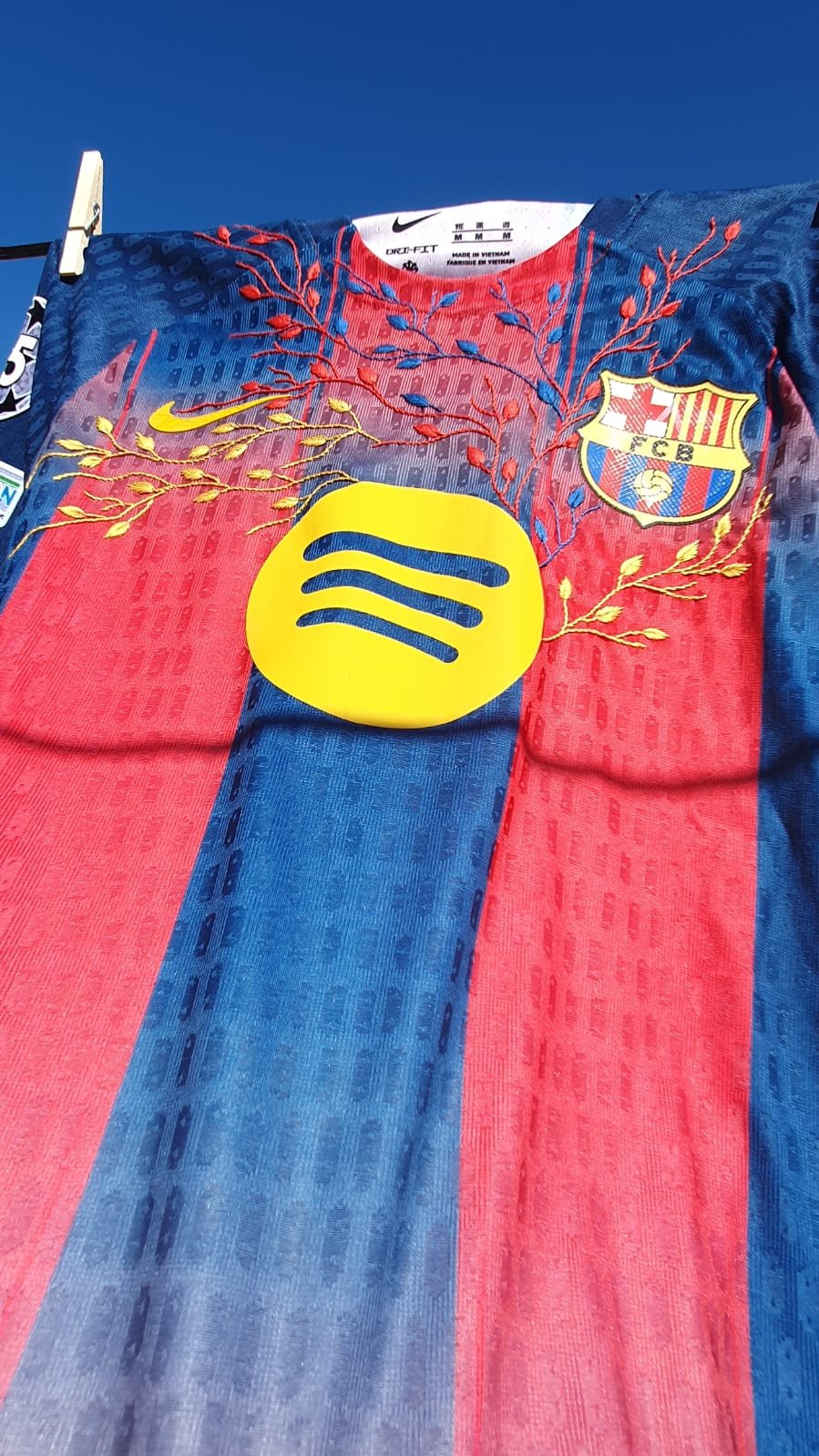 FC Barcelona Nike jersey hanging on clothesline with red and blue stripes, Spotify logo, and FCB crest