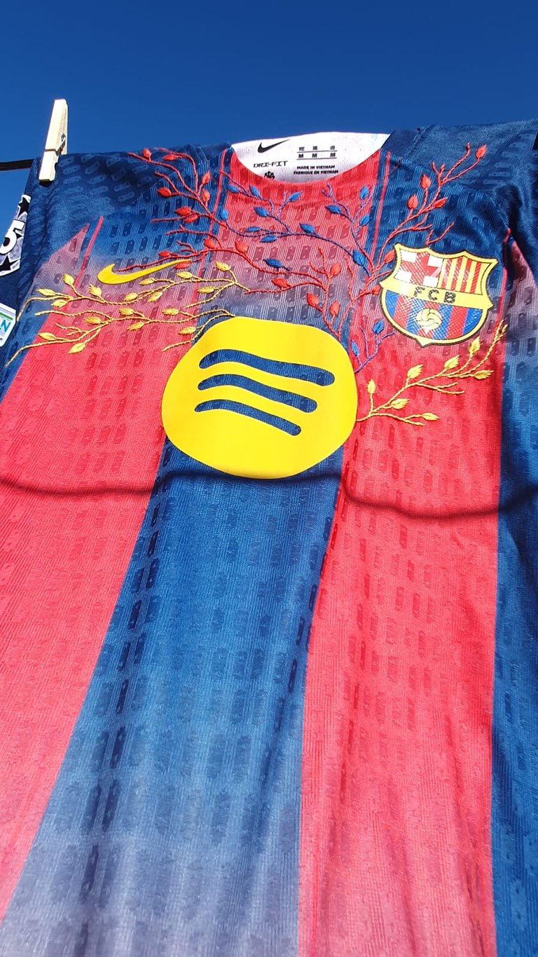 FC Barcelona Nike jersey hanging on clothesline with red and blue stripes, Spotify logo, and FCB crest