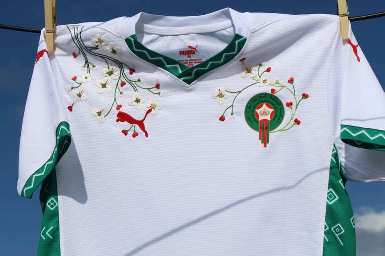 White sports jersey with green trim and festive embroidered designs