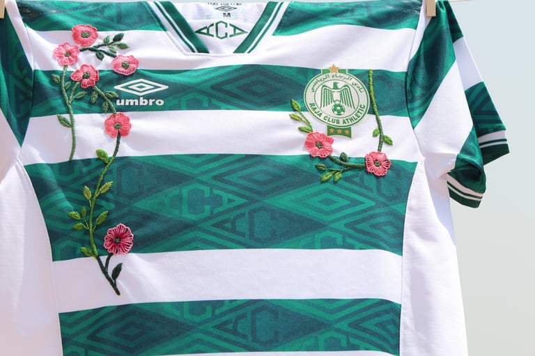 Green and white striped sports jersey with pink flowers and club crest emblem